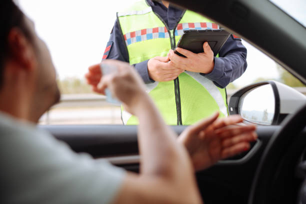 Motorista distraído no trânsito sendo multado por uso do celular ao volante
